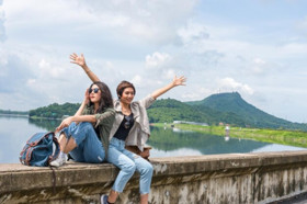 Ilustrasi dua perempuan menikmati suasana di tempat wisata. Berikut rekomendasi tempat wisata di Bandung lagi hits. (FOTO: Freepik).