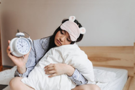WAKTU TIDUR IDEAL - Ilustrasi seorang perempuan merasa masih ngantuk dan menunjukkan waktu pada jam. Berikut ini adalah waktu berkualitas untuk tidur. Ilustrasi/Freepik.